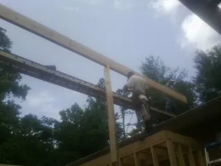 Carpenter setting a ridge beam over a new addition frame — Ice Dam Removal by Roofing Brothers in Murphy